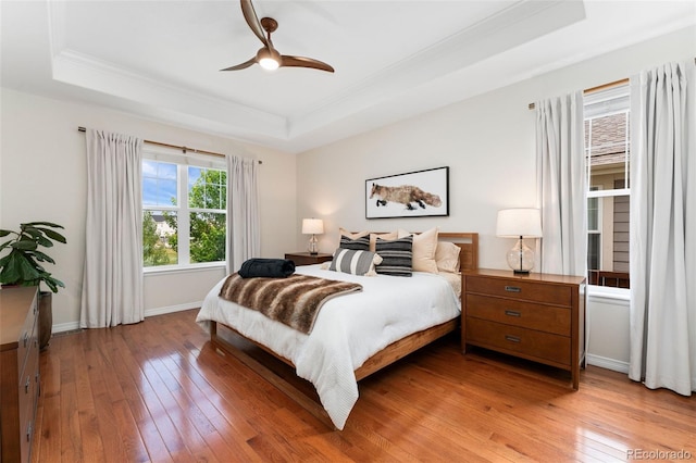 6046 Gilbert Way, Golden, CO 80403 - bedroom featuring a tray ceiling, light wood-style floors, ornamental molding, and a ceiling fan