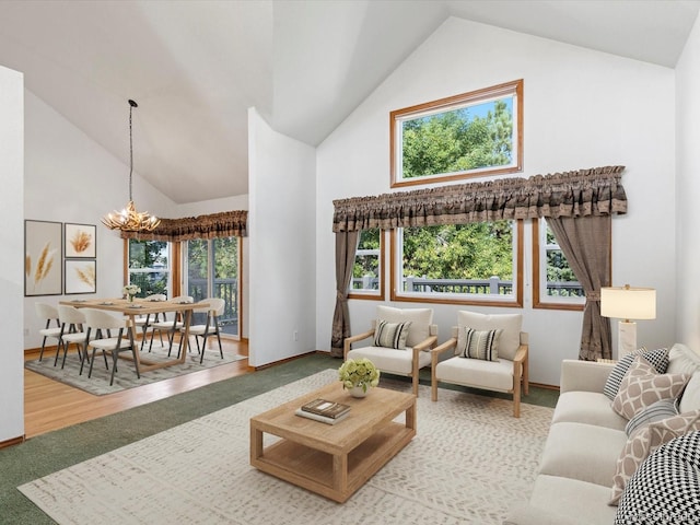 living room with high vaulted ceiling, a notable chandelier, and light hardwood / wood-style flooring