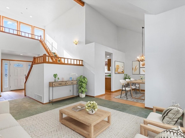 living room with a high ceiling, hardwood / wood-style flooring, and an inviting chandelier