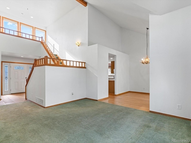 unfurnished living room with a high ceiling and light colored carpet