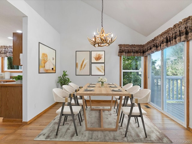 dining room featuring lofted ceiling, an inviting chandelier, and light hardwood / wood-style flooring