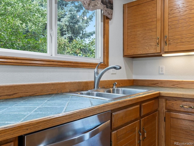 kitchen featuring tile countertops, dishwasher, and sink