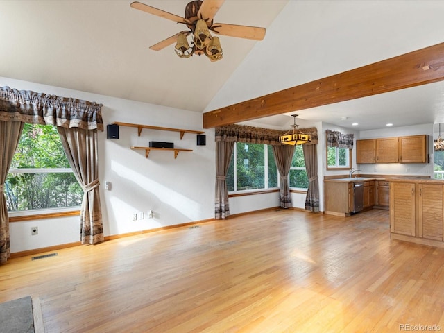 unfurnished living room featuring high vaulted ceiling, ceiling fan with notable chandelier, sink, and light hardwood / wood-style flooring