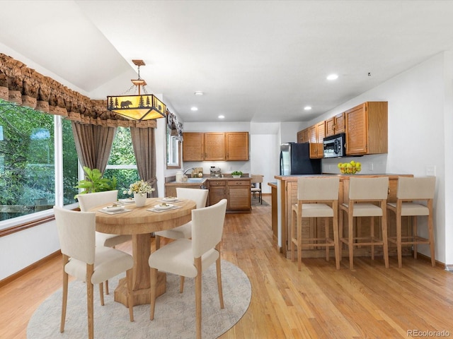 dining area featuring lofted ceiling and light hardwood / wood-style flooring