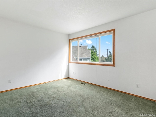 spare room with a textured ceiling and carpet flooring