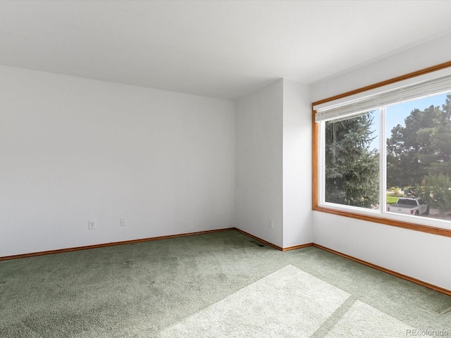 unfurnished room featuring light colored carpet and plenty of natural light