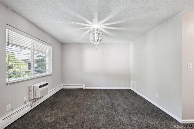 spare room with dark carpet, a textured ceiling, an AC wall unit, and baseboards