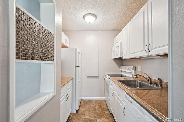 kitchen with a textured ceiling, a sink, baseboards, white cabinetry, and white appliances