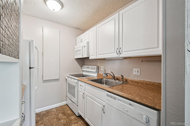 kitchen featuring white cabinets, a sink, a textured ceiling, baseboards, and white appliances