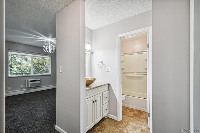 full bathroom with an AC wall unit, a textured ceiling, combined bath / shower with glass door, vanity, and toilet