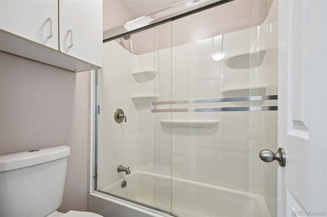 bathroom with bath / shower combo with glass door and toilet