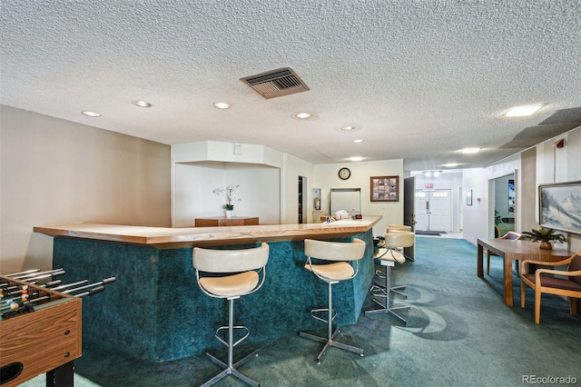 bar with dark colored carpet and a textured ceiling