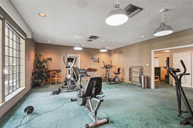 exercise area featuring a textured ceiling, visible vents, and carpet