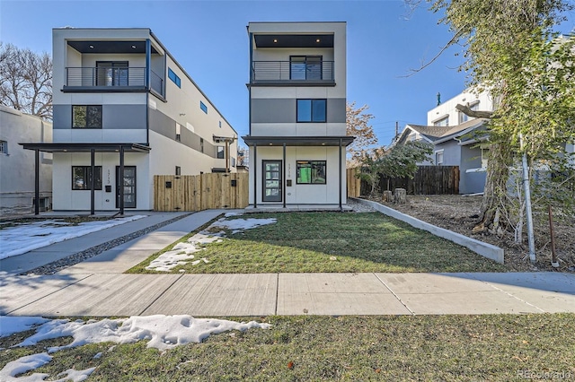 contemporary home with stucco siding, fence, and a balcony