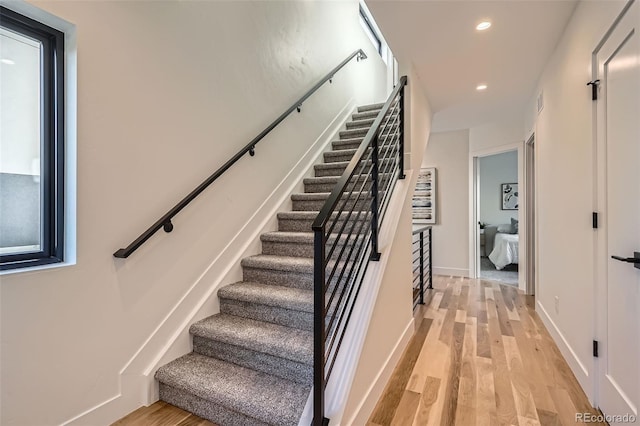 staircase featuring recessed lighting, baseboards, and wood finished floors