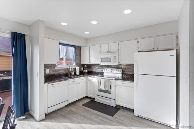 kitchen with sink, white appliances, white cabinetry, and tasteful backsplash