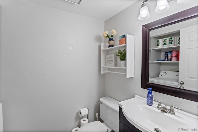 bathroom with washer / dryer, vanity, and toilet