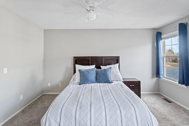 bedroom featuring ceiling fan, light carpet, and a textured ceiling