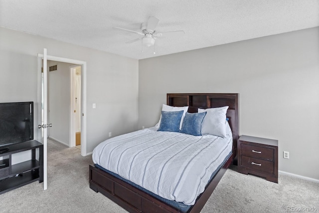 carpeted bedroom featuring ceiling fan and a textured ceiling