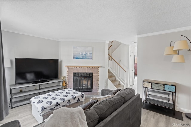 living room with ornamental molding, light hardwood / wood-style flooring, and a tiled fireplace