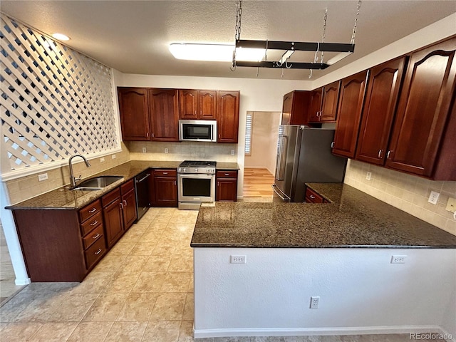 kitchen with sink, appliances with stainless steel finishes, beamed ceiling, dark stone counters, and decorative backsplash