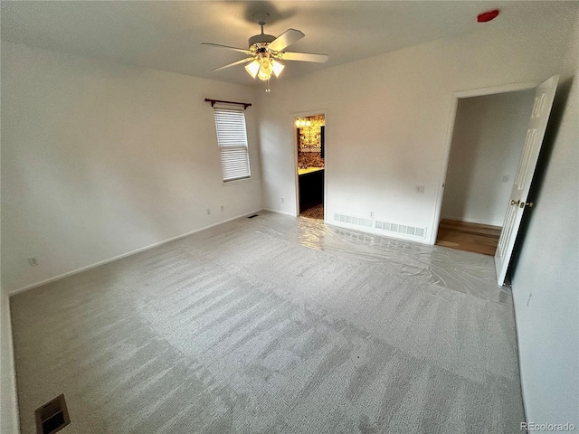 unfurnished bedroom with ceiling fan, connected bathroom, and light colored carpet