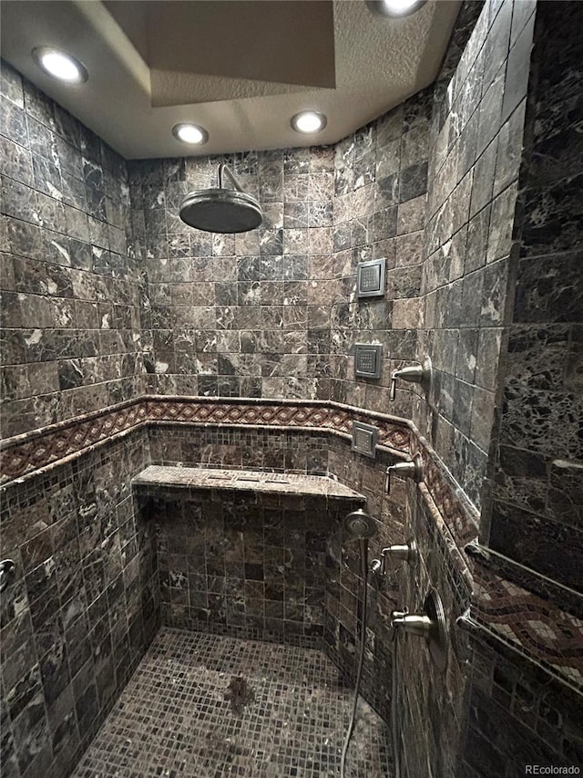 bathroom featuring a tile shower and a textured ceiling