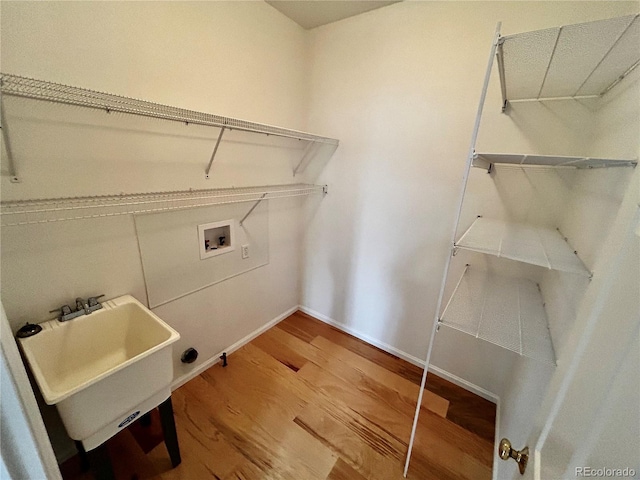 laundry room with hookup for a washing machine, wood-type flooring, and sink