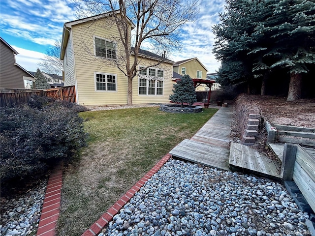 back of property featuring a wooden deck and a yard