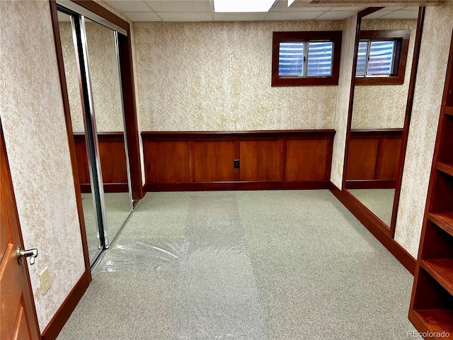 carpeted empty room featuring a paneled ceiling