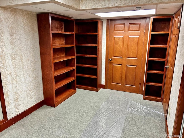 interior space featuring a paneled ceiling and carpet