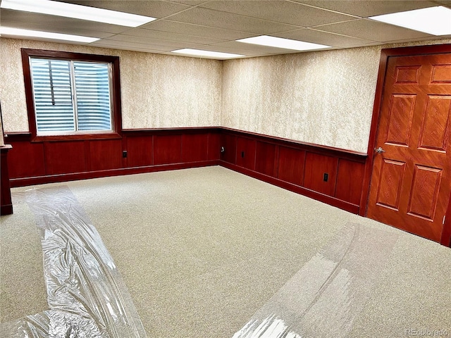 unfurnished room with a paneled ceiling and carpet