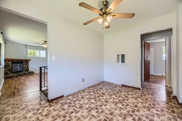 1750 S Dale Ct, Denver, CO 80219 - unfurnished room with ceiling fan, a fireplace, and wood finished floors