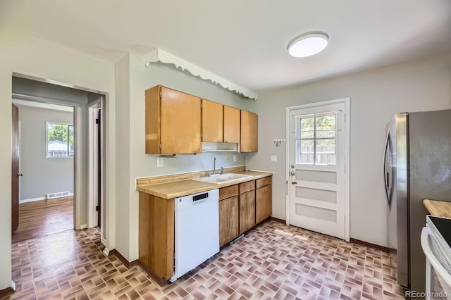 1750 S Dale Ct, Denver, CO 80219 - kitchen with white dishwasher, brick patterned floors, freestanding refrigerator, and light countertops