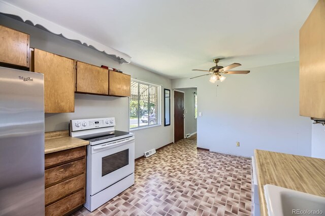 1750 S Dale Ct, Denver, CO 80219 - kitchen featuring freestanding refrigerator, electric range, ceiling fan, light countertops, and brick patterned flooring