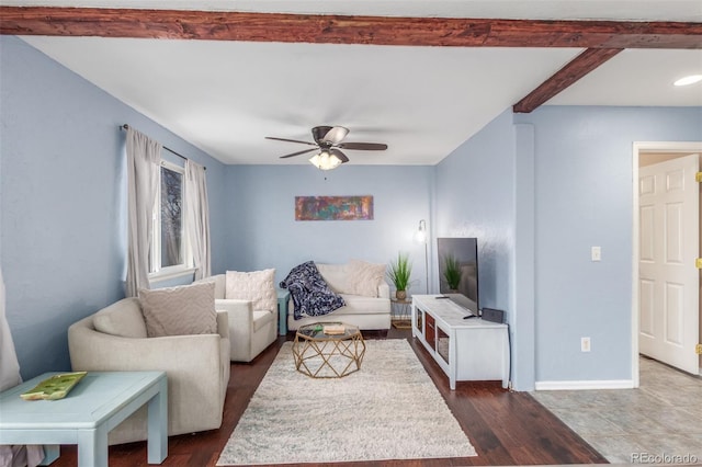 living area featuring ceiling fan, baseboards, dark wood-style flooring, and beamed ceiling