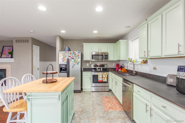 kitchen featuring green cabinets, appliances with stainless steel finishes, a sink, and visible vents