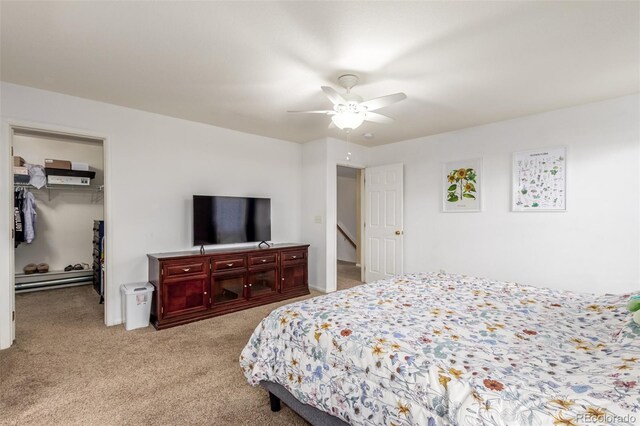 bedroom featuring light carpet, ceiling fan, a spacious closet, and a closet