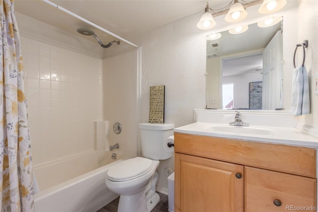 bathroom with shower / tub combo, a textured wall, vanity, and toilet