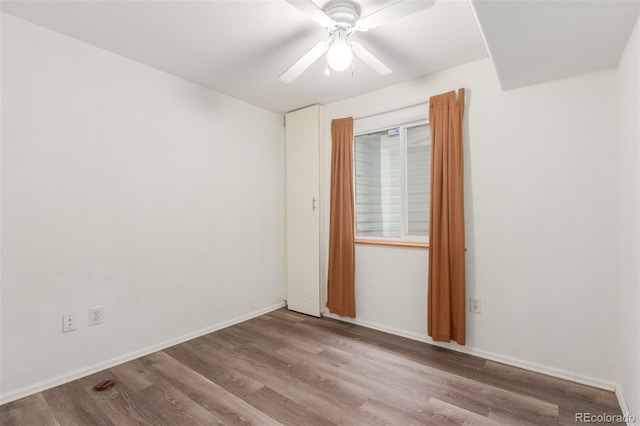 empty room with ceiling fan, baseboards, and wood finished floors