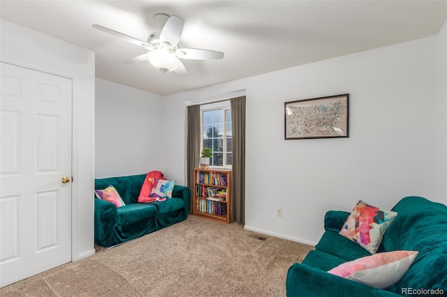 living area with carpet floors, baseboards, and a ceiling fan