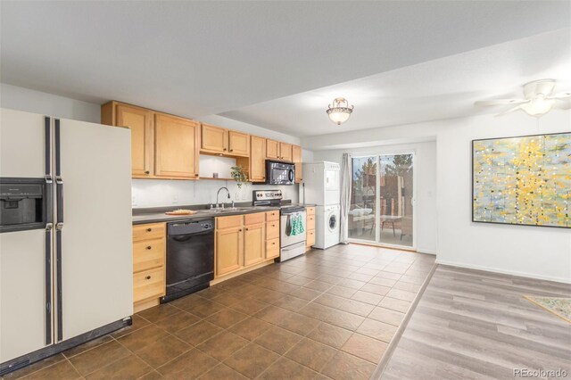 kitchen with light brown cabinets, open shelves, stacked washing maching and dryer, black appliances, and dark countertops