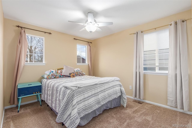 carpeted bedroom featuring multiple windows, visible vents, and baseboards