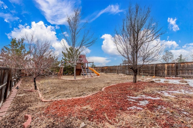 view of yard with a playground and a fenced backyard