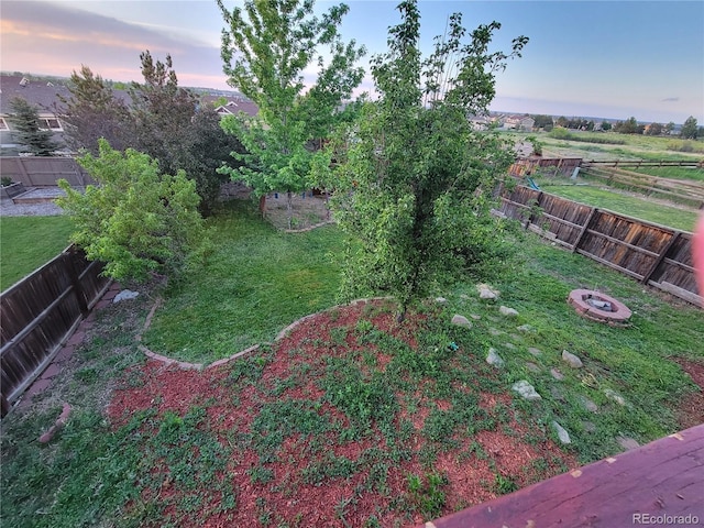 view of yard with a fenced backyard and a fire pit