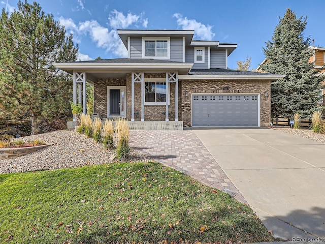 view of front of home with a garage, a front lawn, and a porch