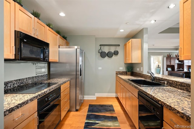 300 W 11th Ave Unit 15F, Denver, CO 80204 - kitchen with black appliances, a sink, light brown cabinetry, light wood finished floors, and recessed lighting