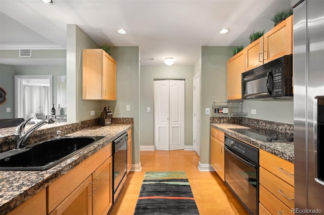 300 W 11th Ave Unit 15F, Denver, CO 80204 - kitchen with black appliances, a sink, light brown cabinetry, dark countertops, and light wood-style flooring