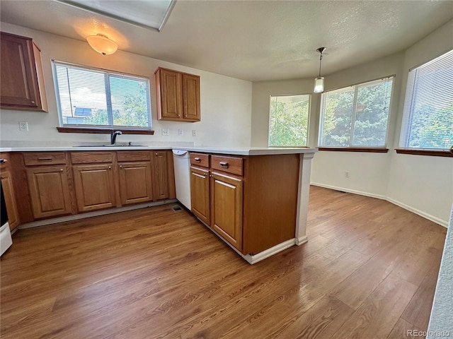 13191 Umatilla St, Denver, CO 80234 - kitchen featuring a peninsula, brown cabinetry, and healthy amount of natural light
