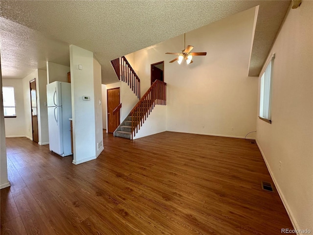 13191 Umatilla St, Denver, CO 80234 - unfurnished living room with ceiling fan, a textured ceiling, dark wood finished floors, and stairs